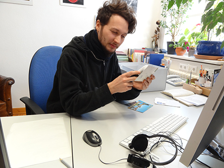 Praktikant Lukas Wittstatt beim Inspizieren einer Postkarte