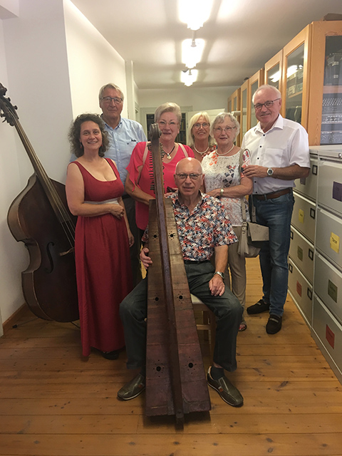 Armin Hartig, Ilse Miltenberger, Otto Miltenberger (sitzend an der Harfe), Marga Hartig, Evi Happel und Alfred Happel haben sich mit Heidi Christ um Otto Miltenbergers Harfe versammelt.